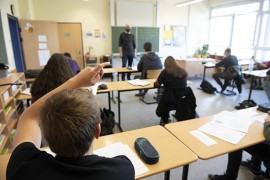 Schule zur Zeit von Corona Schüler meldet sich in Klassenraum