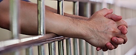 Unfreie Personen (Gefangene) Arme durch Gitterstäbe gestreckt