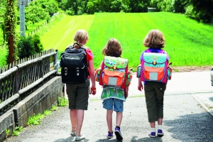 Schulkinder mit Rucksack unterwegs