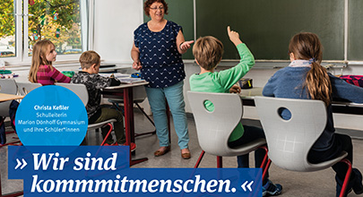 Kommmitmensch Bildung Lehrerin mit Kindern im Klassenraum