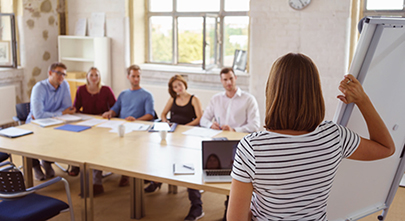 Besprechung Seminar Arbeitsgruppe Frau hält Vortrag vor ein paar Menschen